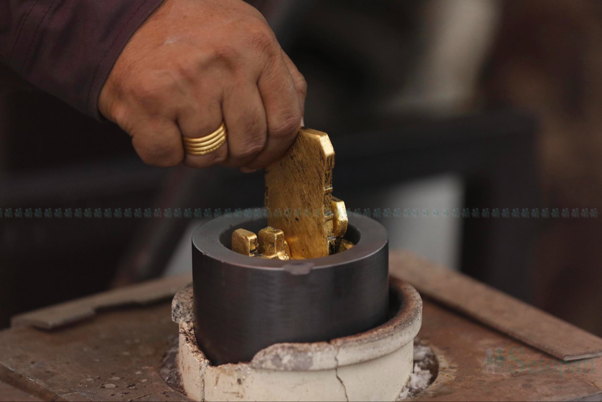 तस्करहरूले ब्रेक शुमा लुकाएर ल्याएको सुन गालेर बिस्कुट आकारको बनाउँदै राष्ट्र बैंक टक्सार विभागका अधिकारी। तस्बिर: नवीनबाबु गुरूङ/सेतोपाटी